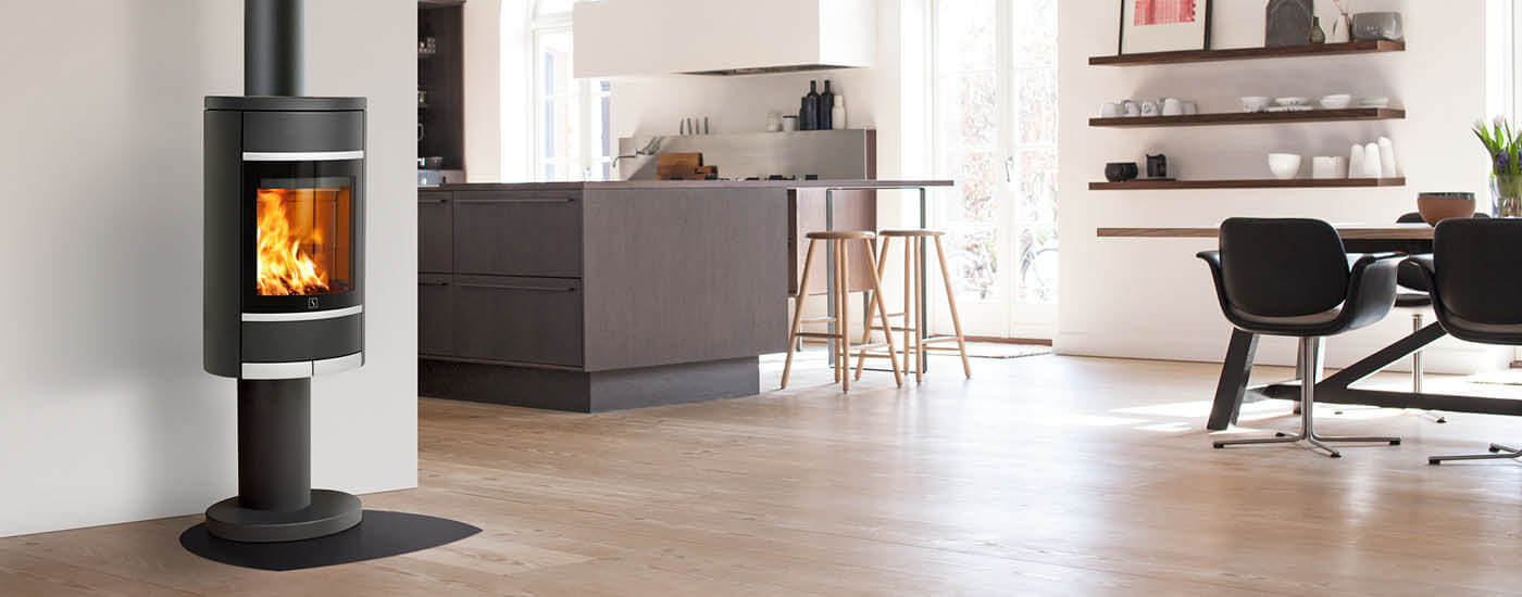 Zwarte open haard op zuil Scan 68-4 in keuken met donkerbruin houten meubilair en eethoek met leren stoelen