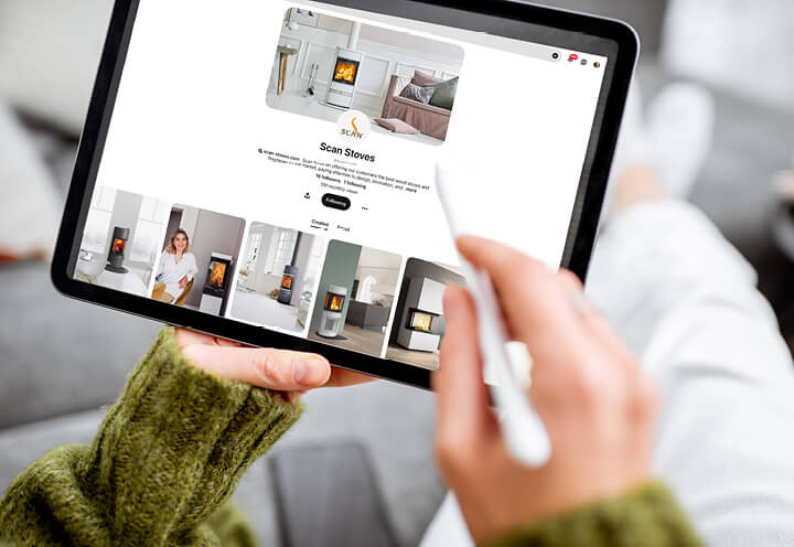 Close-up van handen die een tablet vasthouden en scrollen op pinterest