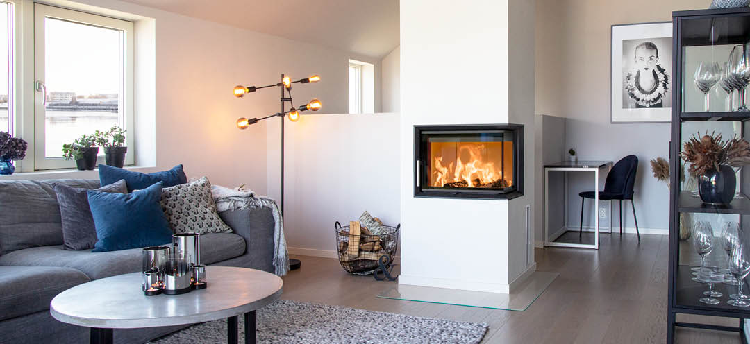 Inbouwhaard met glas aan twee kanten Scan 5003 in een witte moderne woonkamer met grijze bank en zwarte meubels