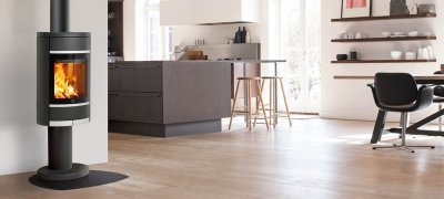 Zwarte open haard op zuil Scan 68-4 in keuken met donkerbruin houten meubilair en eethoek met leren stoelen