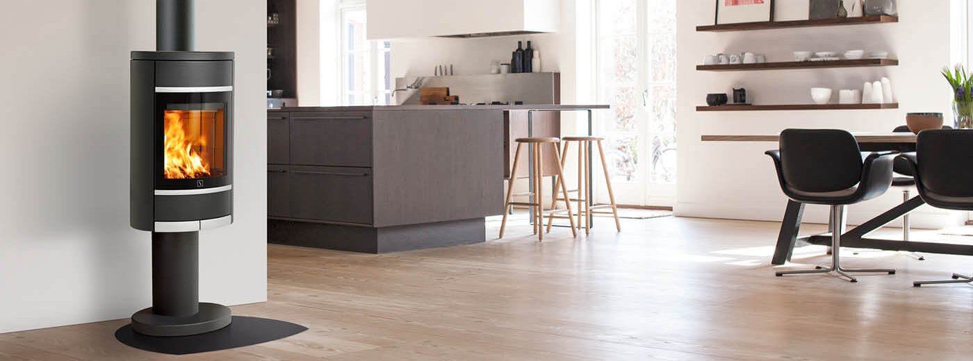 Zwarte open haard op zuil Scan 68-4 in keuken met donkerbruin houten meubilair en eethoek met leren stoelen